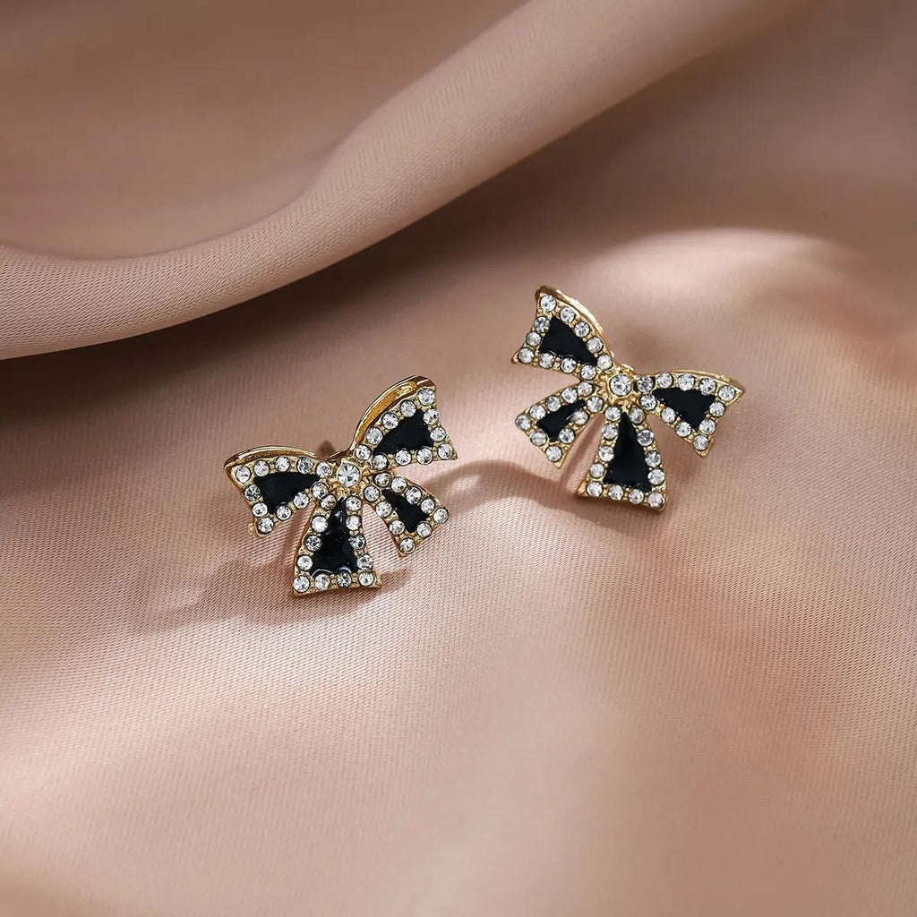 Golden and black-colored bow-shaped studs